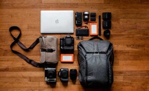 Imagen con una mochila y diferentes productos fotográficos  para viaje